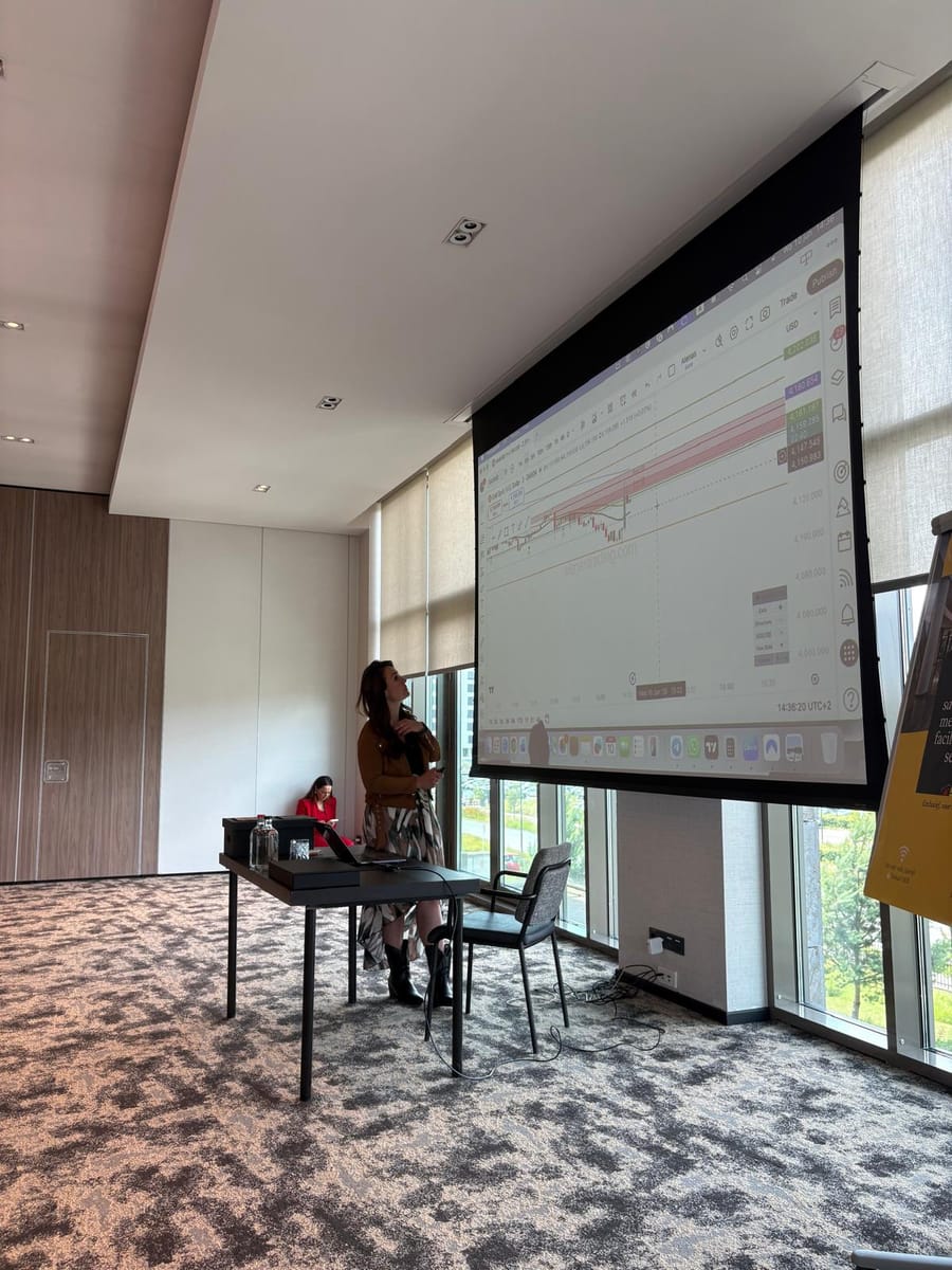 The session room, floor-to-ceiling windows along one side and the projection screen at the front.